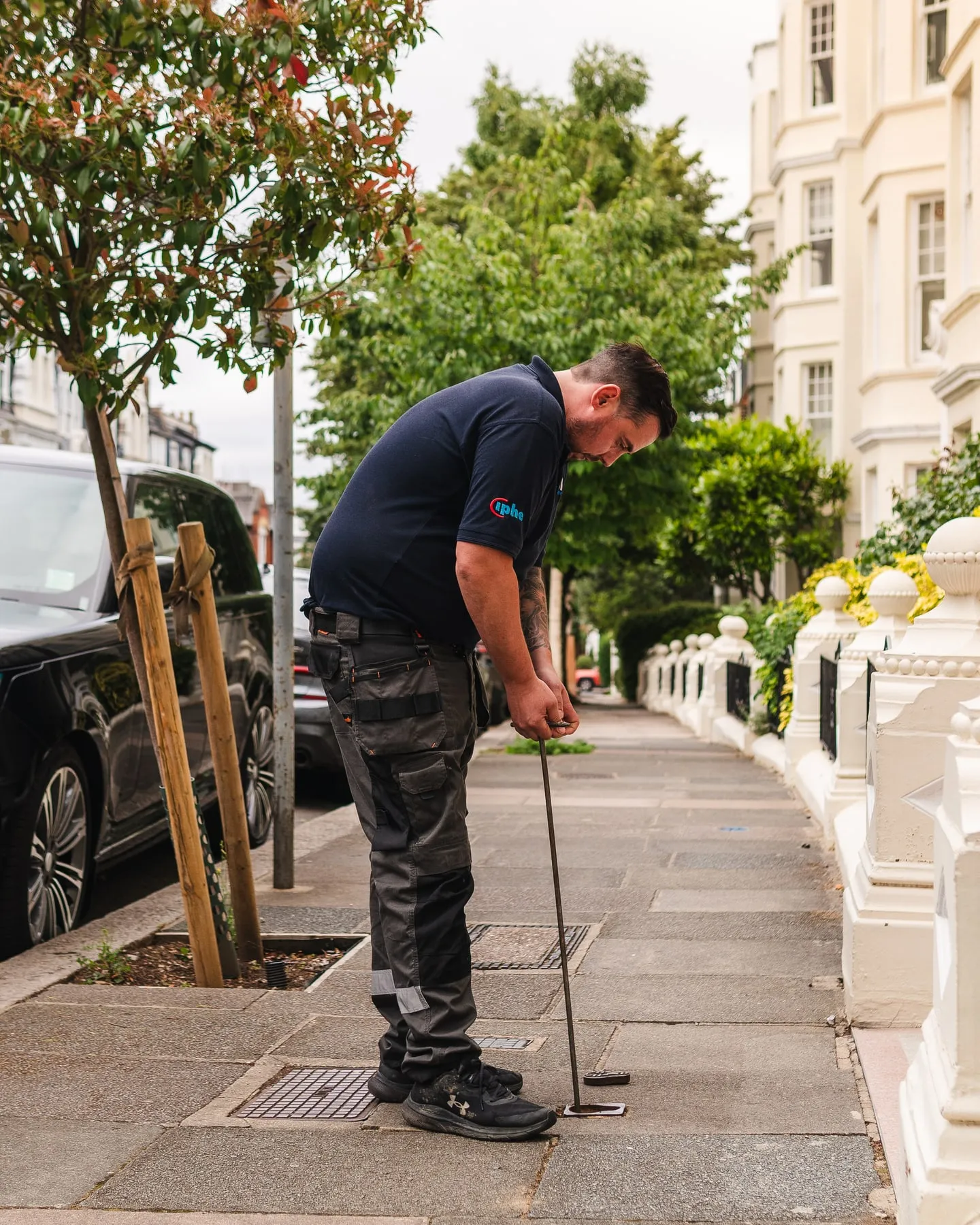 ADI engineer checking pavement access covers outside terraced homes
